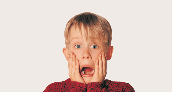 Macaulay Culkin as Kevin from Home Alone puts his hands to his face and looks very shocked.