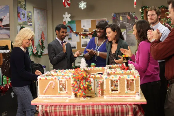 Parks and Recreation cast with gingerbread house