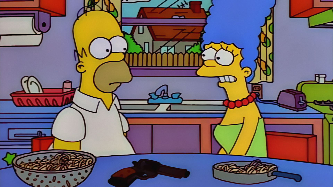 Marge and Homer are sitting at the kitchen table in The Simpsons.