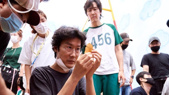 The director examines a sugar wafer used in game play on the set of “Squid Game”