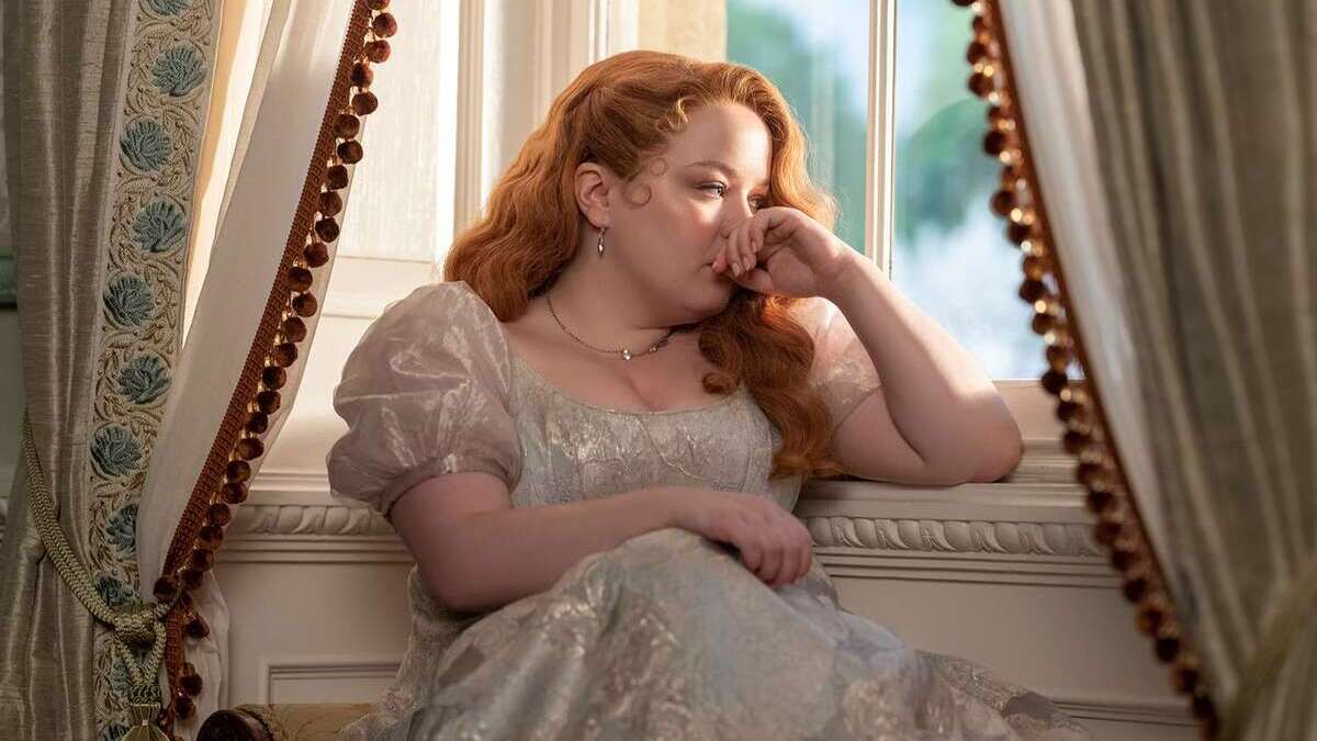 A forlorn Penelope Featherington (Nicola Coughlan) sits by the window in a still from Bridgerton season 3