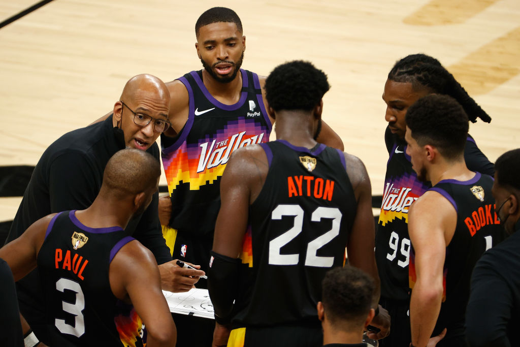 Phoenix Suns coach Monty Williams talks to his huddle of players, including Chris Paul and Devin Booker.
