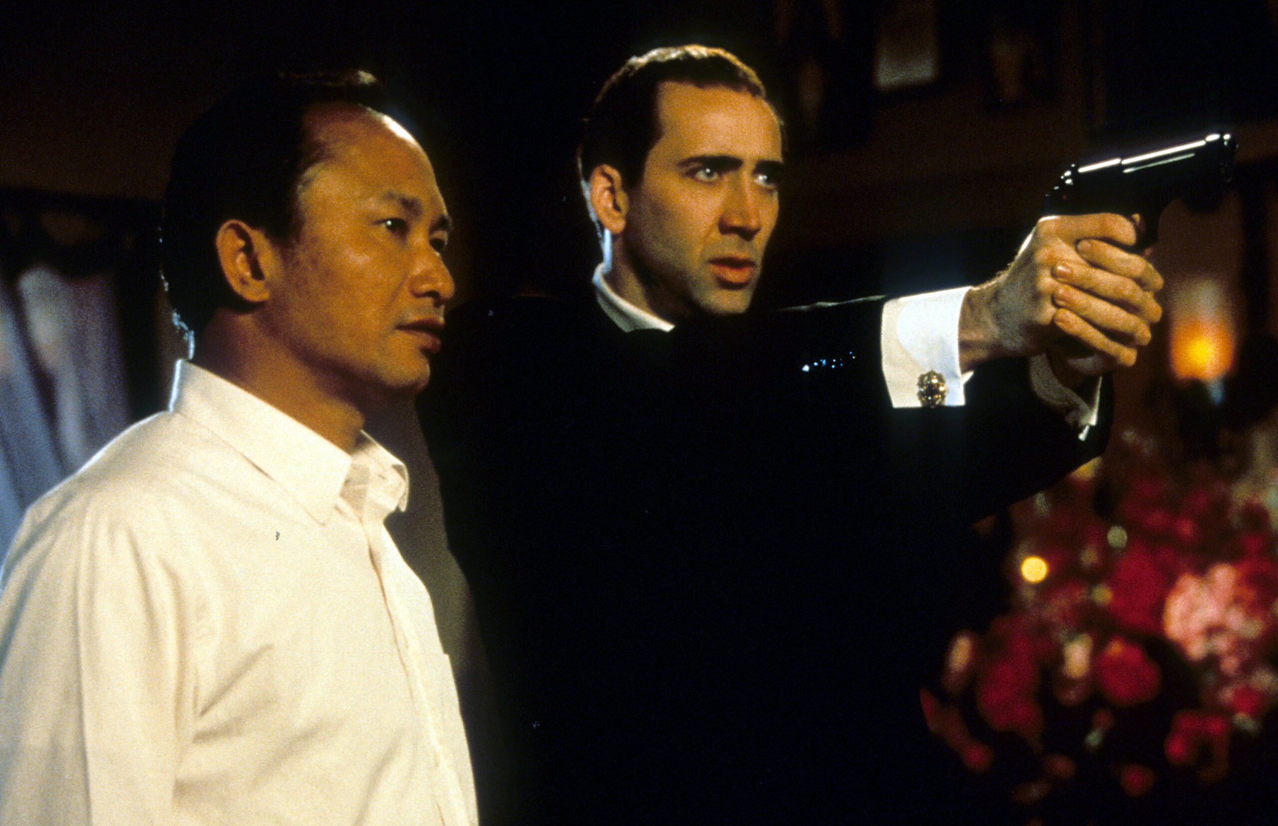Director John Woo watches as Nicolas Cage during filming of Face/Off