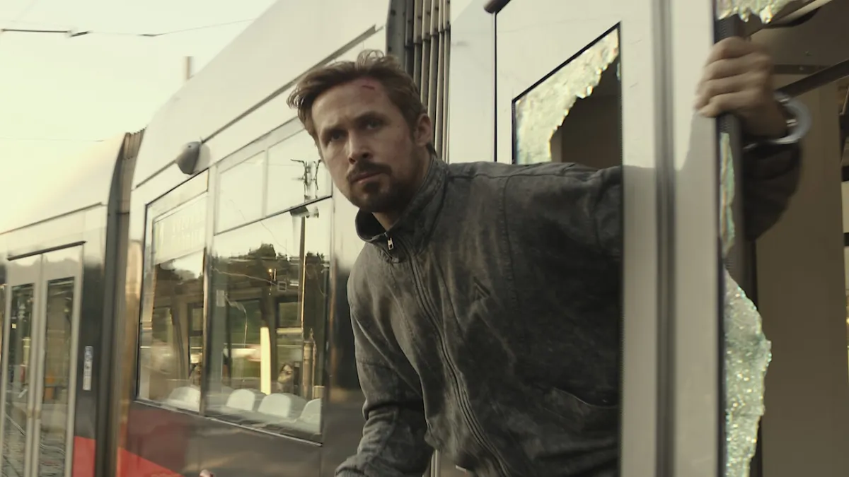 Ryan Gosling looks out of a broken window in The Gray Man