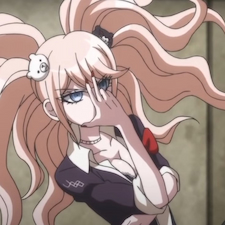 Junko holding up two fingers to her head and in black outfit