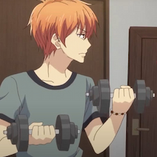 Kyo busy lifting weights while standing in a grey shirt