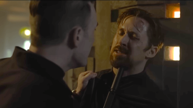 Chris Evans pressing a gun under Ryan Gosling's chin in 'Gray Man'