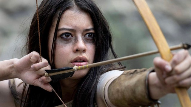 Amber Midthunder in character as Comanche Nation warrior Naru in “Prey,” preparing to shoot an arrow