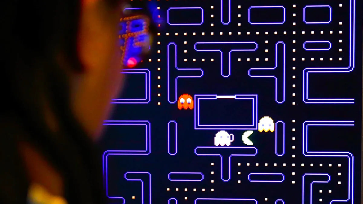 A close-up of a PAC-Man screen, with a partial profile of player’s face