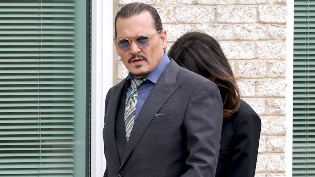 Johnny Depp, his hair slicked back in a ponytail and wearing a glasses
