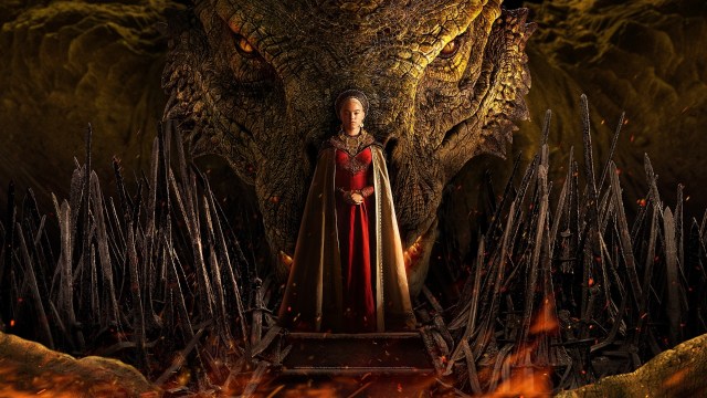 Milly Alcock, as a platinum-haired Targaryen royal, stands in front of a huge dragon in “House of the Dragon”