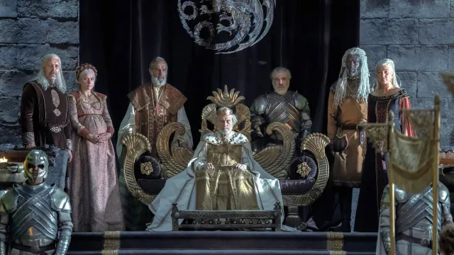 King Jaehaerys sits on his throne flanked on either side by members of the royal court and family.