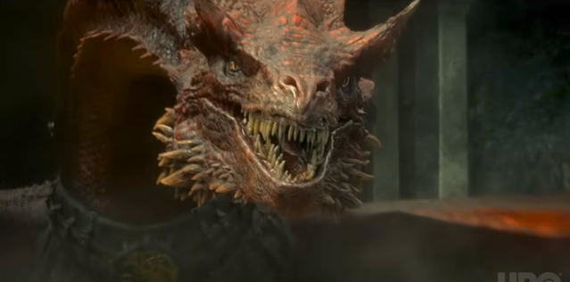 A massive, scaly, snarling, red dragon whose head takes up the majority of the frame