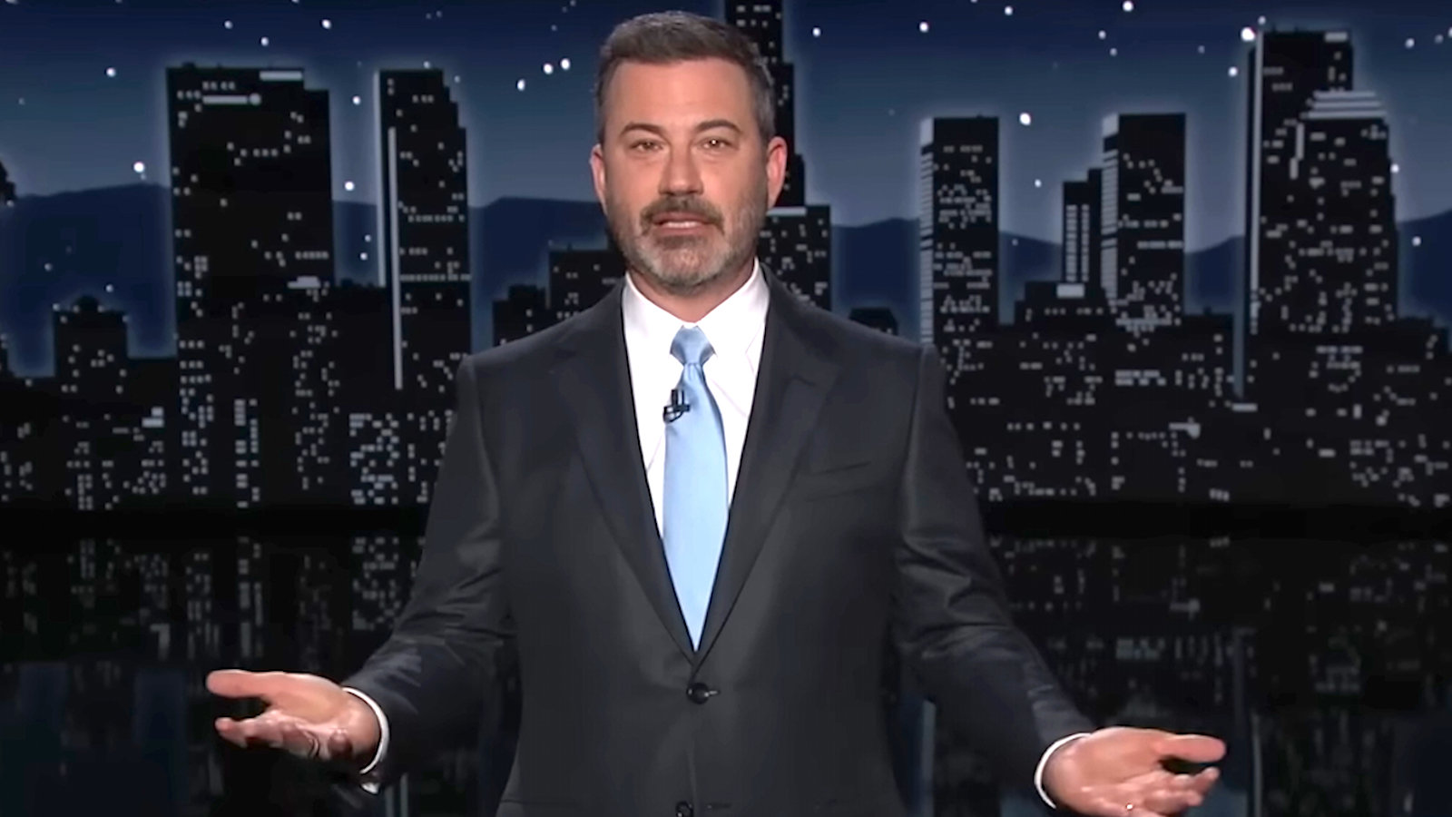 Jimmy Kimmel giving a monologue on Jimmy Kimmel Live wearing a black suit and light blue tie