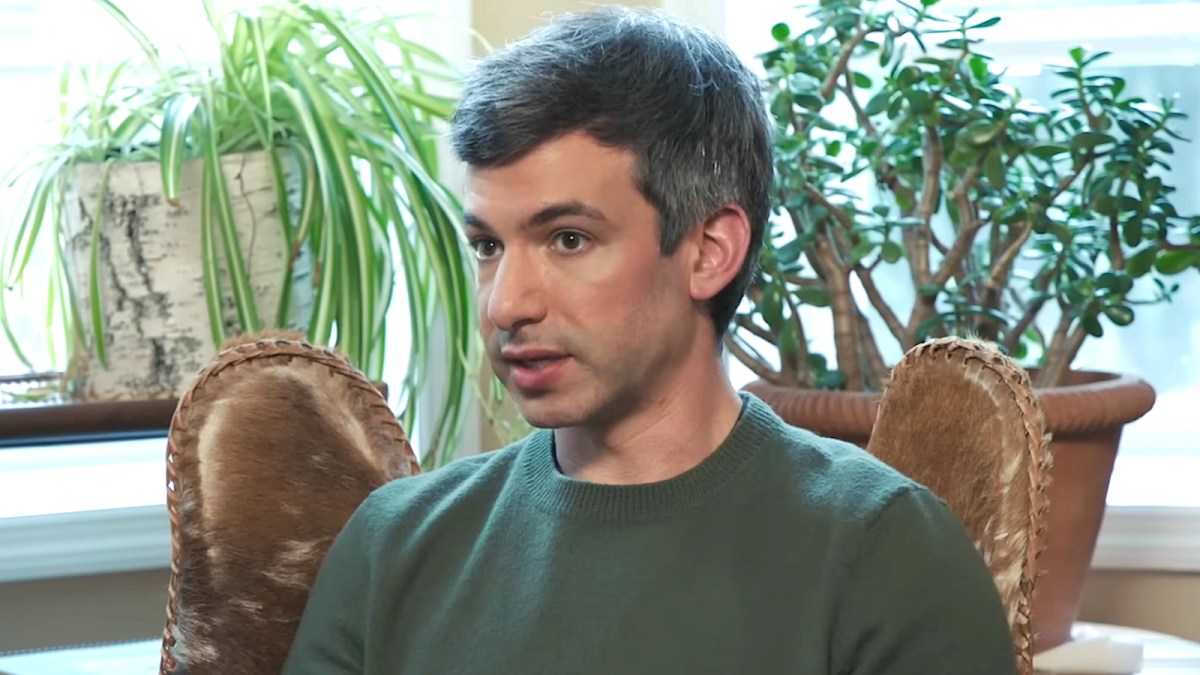 Nathan Fielder in a green shirt and sitting in a chair