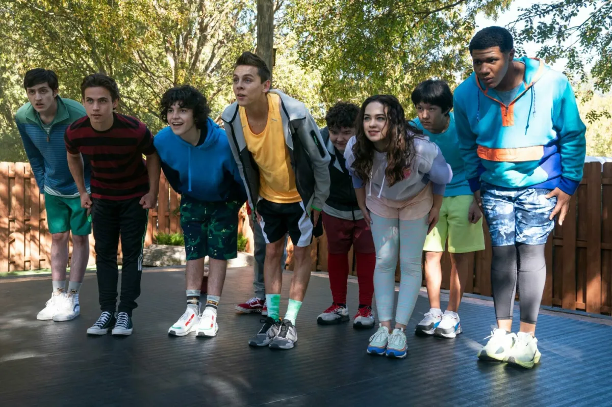 A group of young cast members of “Cobra Kai“ bow as a group in a still from the show.