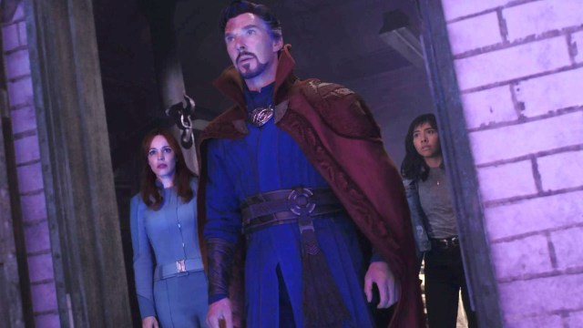 Benedict Cumberbatch in character as Dr. Strange, flanked by two actors, one of whom is Xochitl