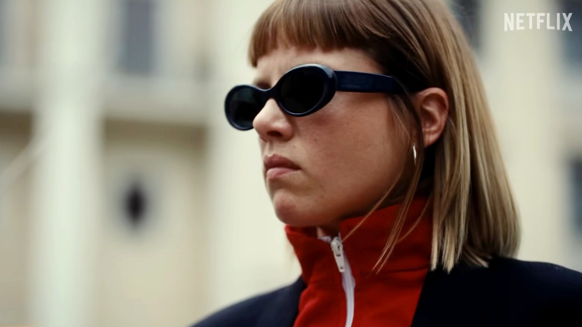 Jella Haase in character as the title character in ‘Kleo,’ wearing sunglasses, a red zip-up turtleneck and a fierce expression