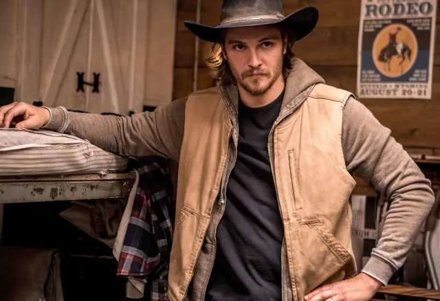 Luke Grimes in character as Kayce Dutton wearing a cowboy hat