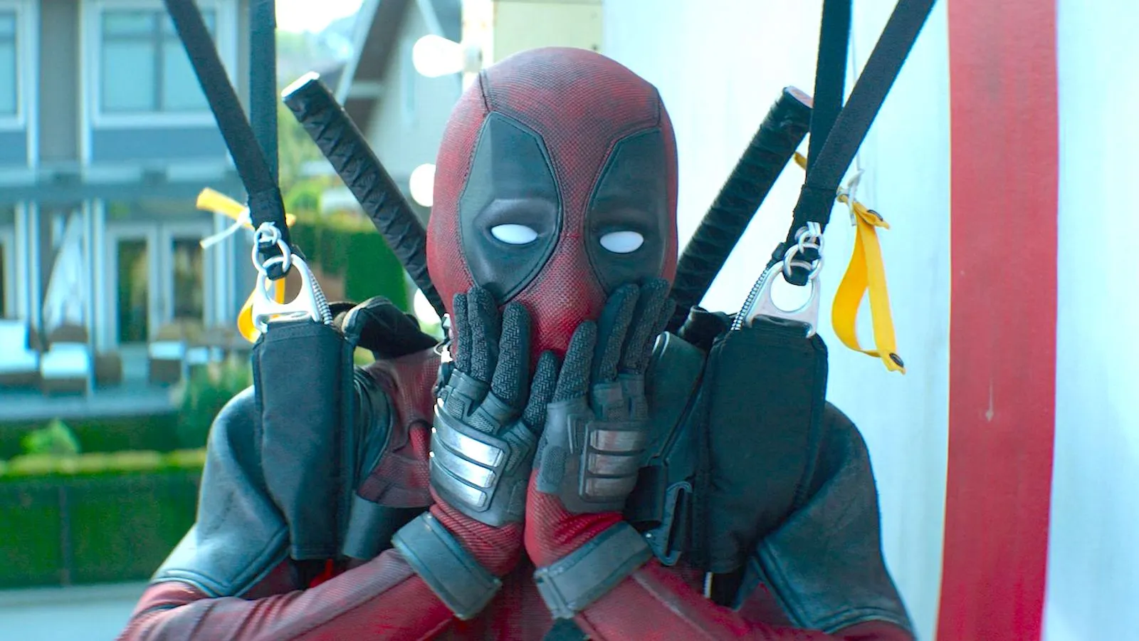 Ryan Reynolds as Deadpool, covering his masked mouth in a shocked expression