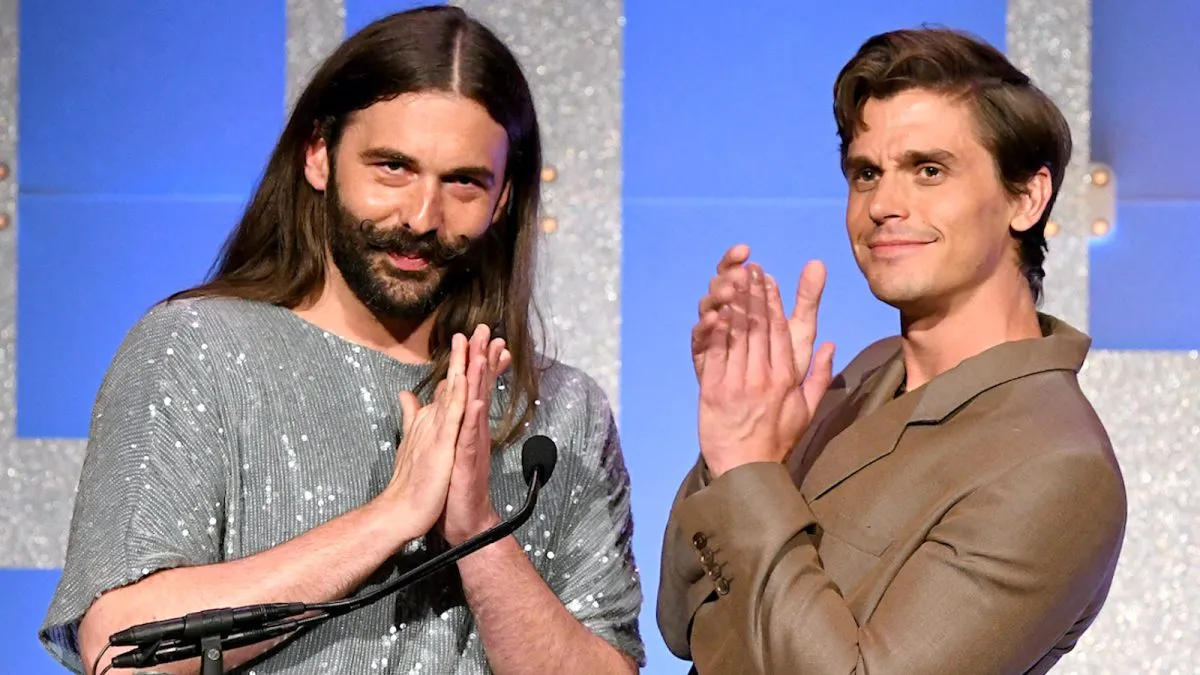 Jonathan Van Ness and Antoni Porowski from 'Queer Eye' stand at a podium clapping