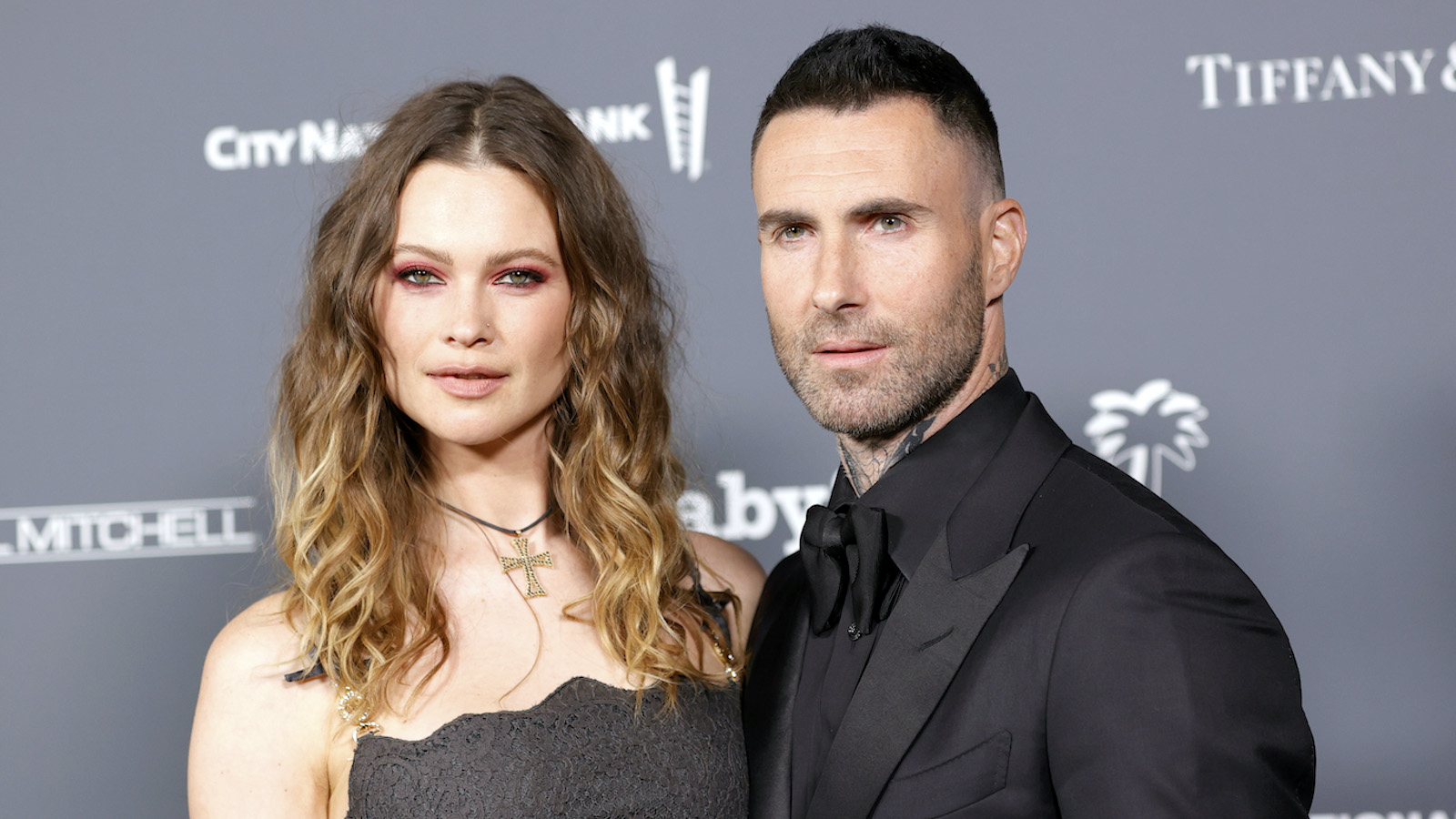 (L) Behati Prinsloo and (R) Adam Levine, both dressed in formal attire on the red carpet