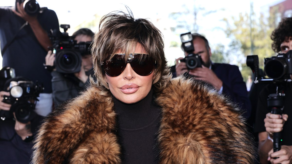 Lisa Rinna in a fur coat and oversized sunglasses, surrounded by paparazzi cameras
