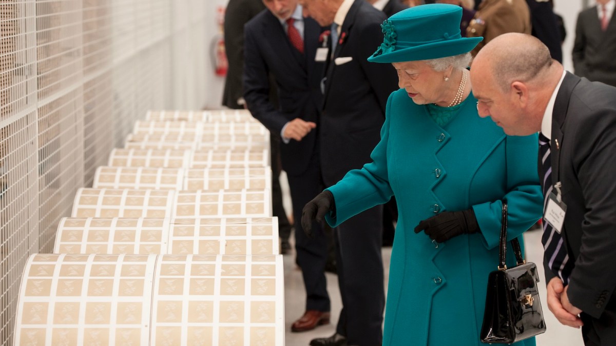 WOLVERHAMPTON, UNITED KINGDOM - OCTOBER 30: Queen Elizabeth II examines large rolls of stamps during an official visit to International Security Printers to view their work on specialist postage stamps on October 30, 2014 in Wolverhampton, England.