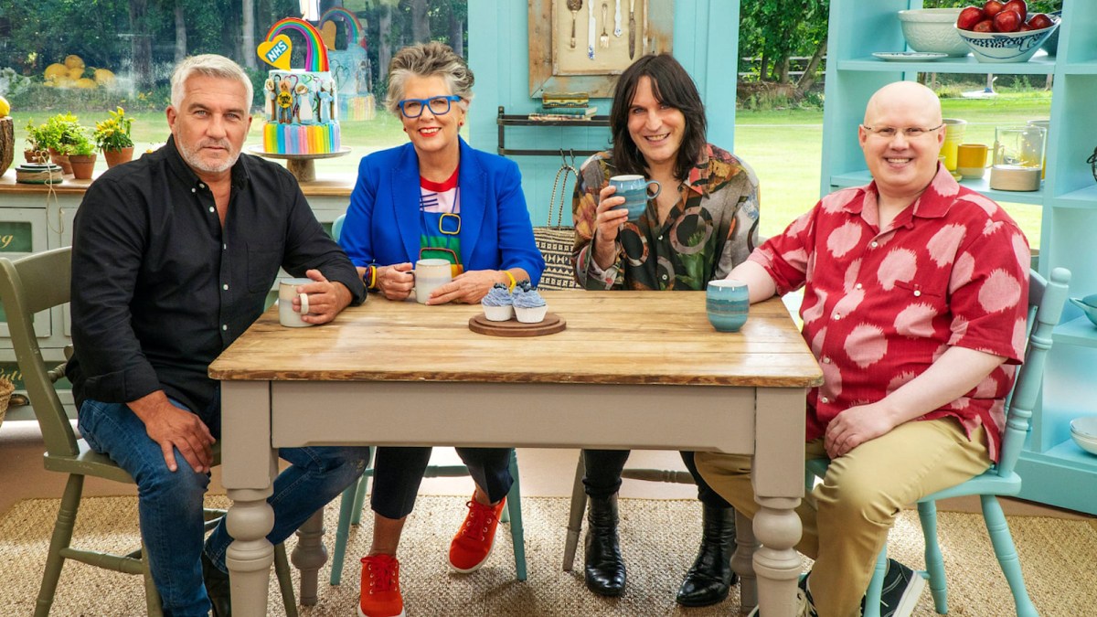 Sitting at a table from left to right, Paul Hollywood, Prue Leith, Noel Fielding, and Matt Lucas from 'The Great British Baking Show'