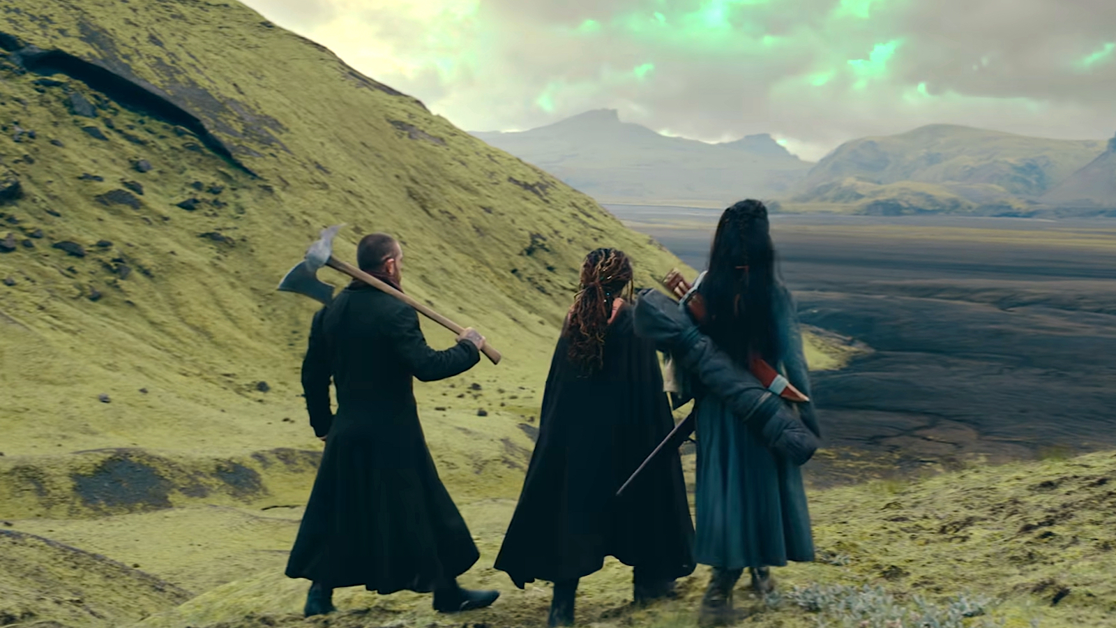 The cast of 'The Witcher: Blood Origin' surrounded by mountains and green clouds