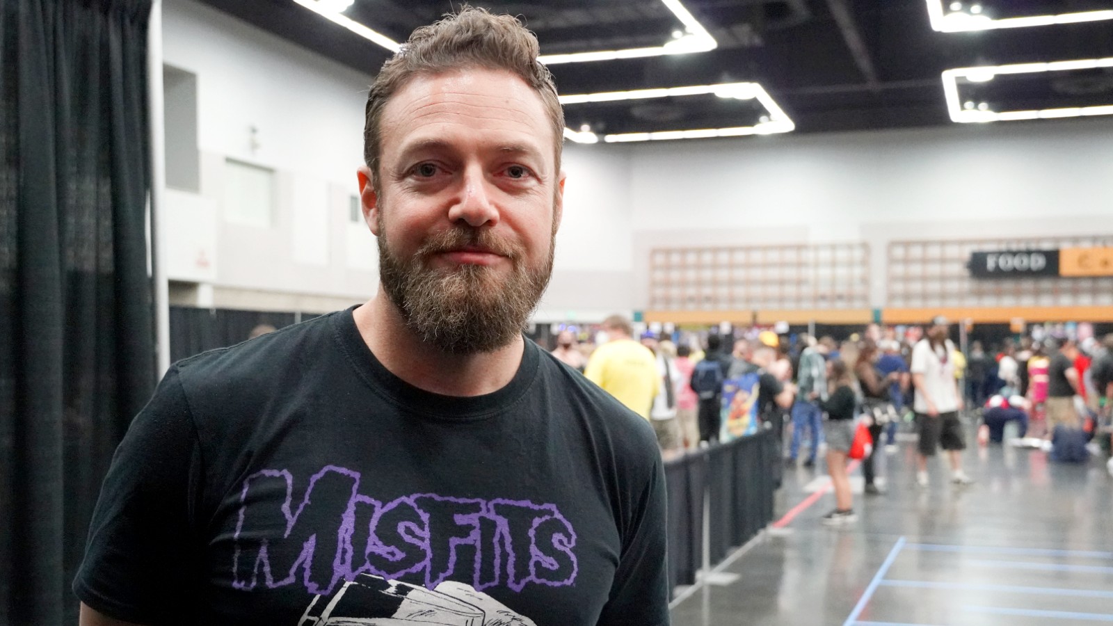 'The Walking Dead' star Ross Marquand stands in a convention hall to great fans.