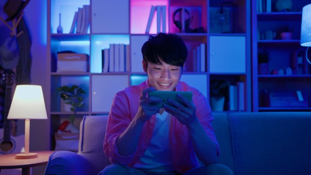 Man plays mobile games - stock photo