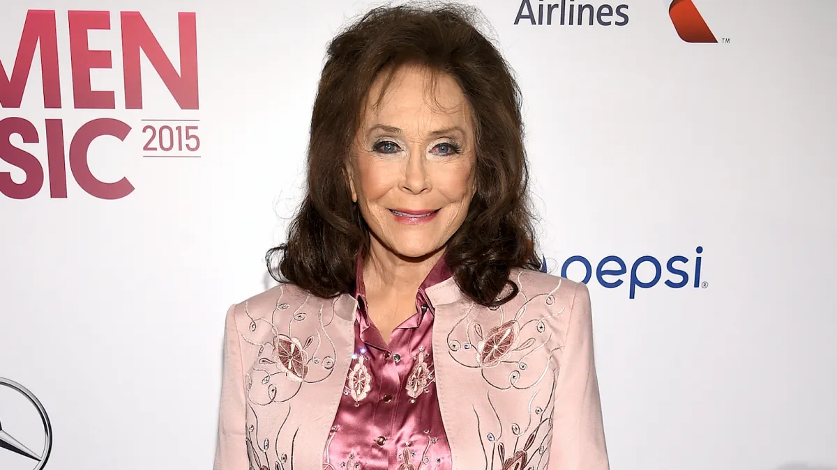 Loretta Lynn in a pale pink blazer and pink blouse on the red carpet