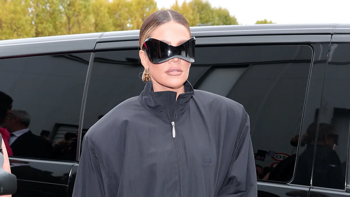 Khloe Kardashian wearing oversized black sunglasses and a black jacket