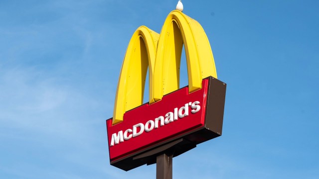 Photo of the McDonald's sign with a seagull sitting on the arch.