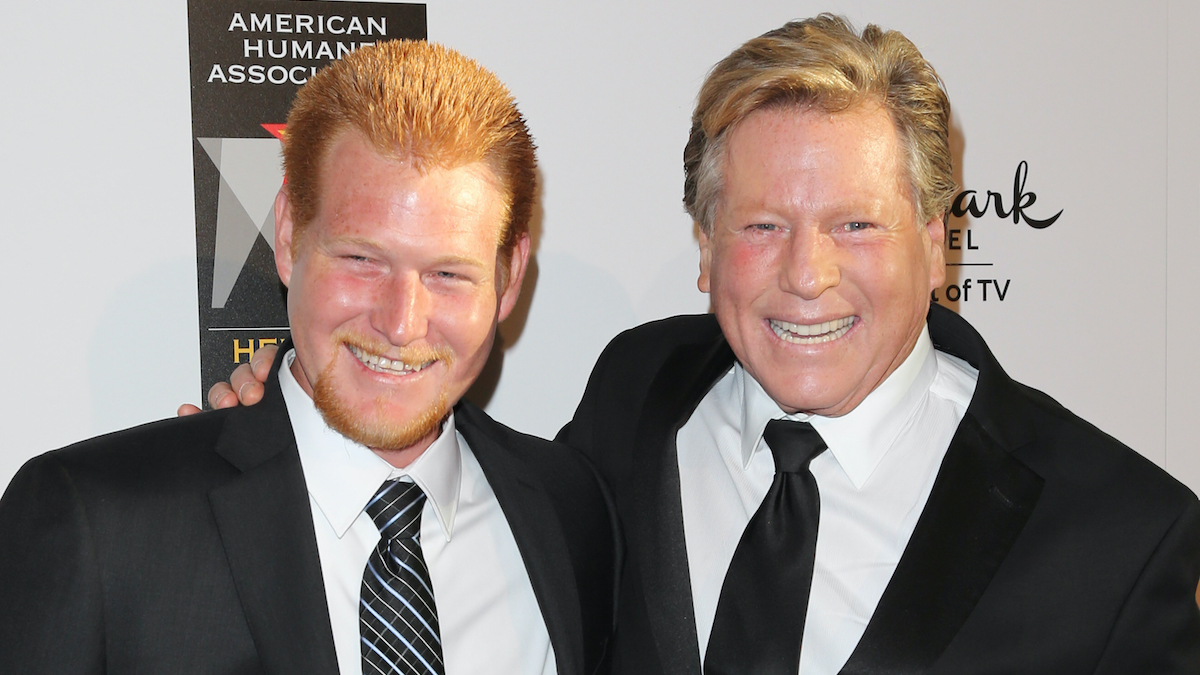 Ryan O'Neal and Redmond O'Neal are standing and posing for a picture.