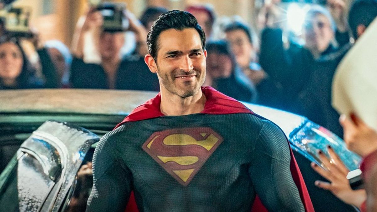 Tyler Hoechlin's Superman grins at an adoring crowd as he steps out of a car in a photo from Superman & Lois season 2
