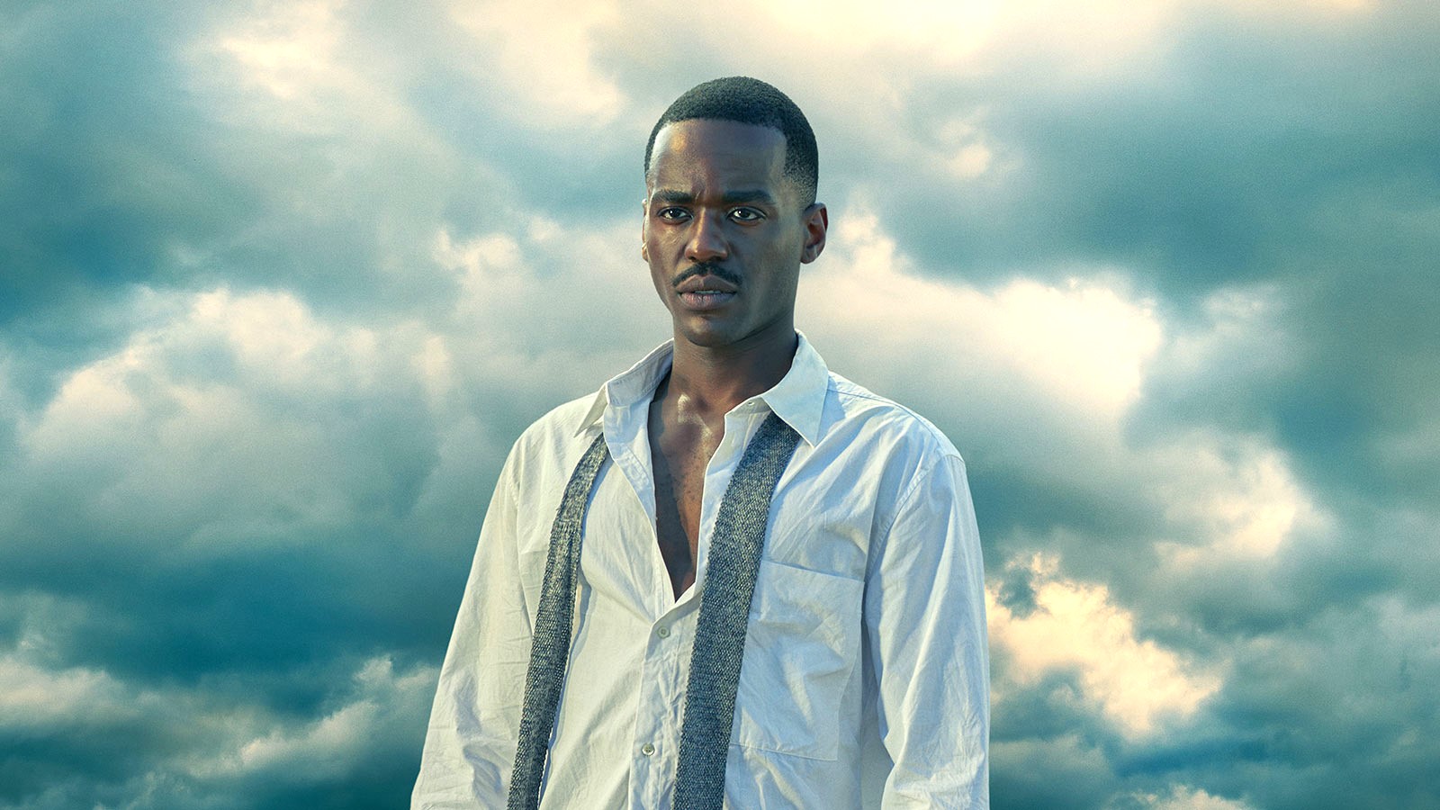 Ncuti Gatwa stands against a cloudy background as the Fifteenth Doctor in 'Doctor Who'