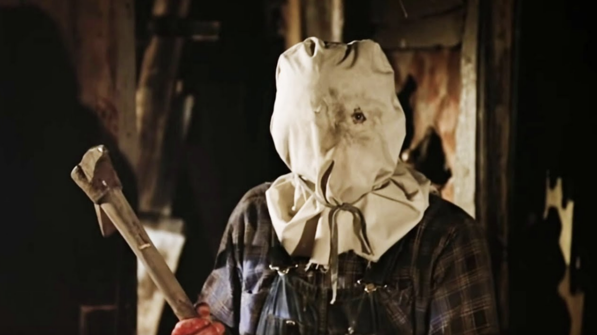 Jason from Friday the 13th Part 2 is wearing a bag on his head and holding a weapon. 
