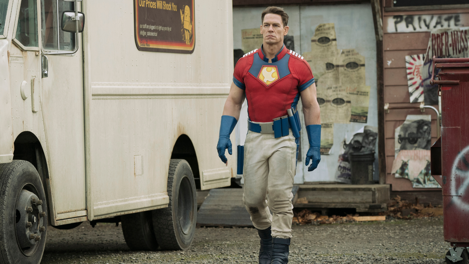 Peacermaker (John Cena) walks alongside a van in 'Peacemaker' (2022).