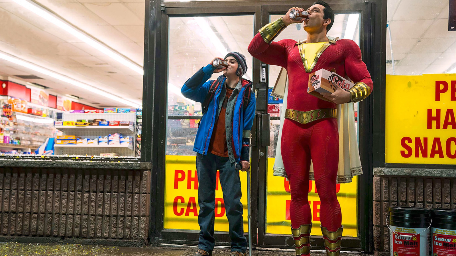 Shazam (Zachary Levi) and Freddy (Jack Dylan Grazer) chug soda outside a convenience store in 'Shazam!' (2019). 