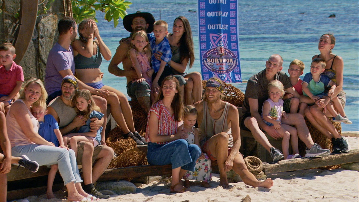 Survivor's cast is huddled around on a beach.