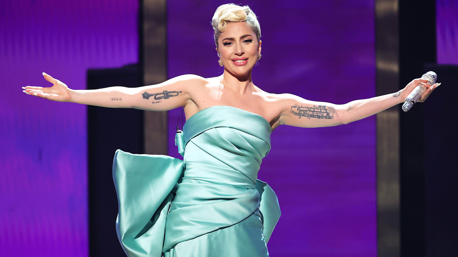 Lady Gaga in a teal colored dress on stage
