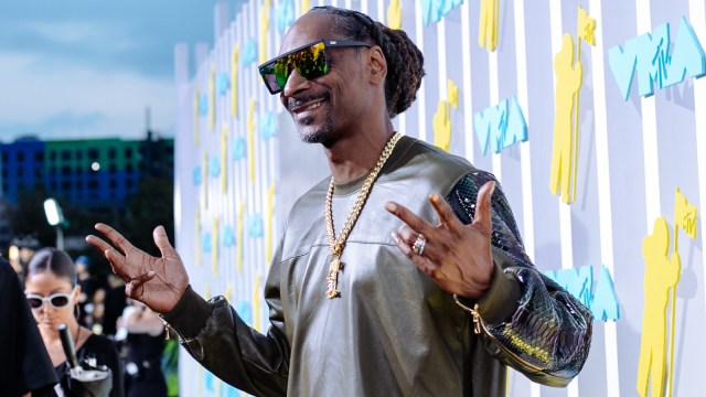 Snoop Dogg strikes a pose during a red carpet event.