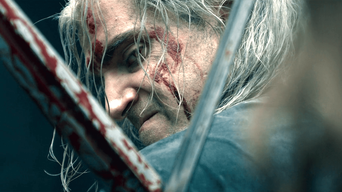 Profile of Geralt of Rivia (Henry Cavill) glaring through the X opening of two connected swords
