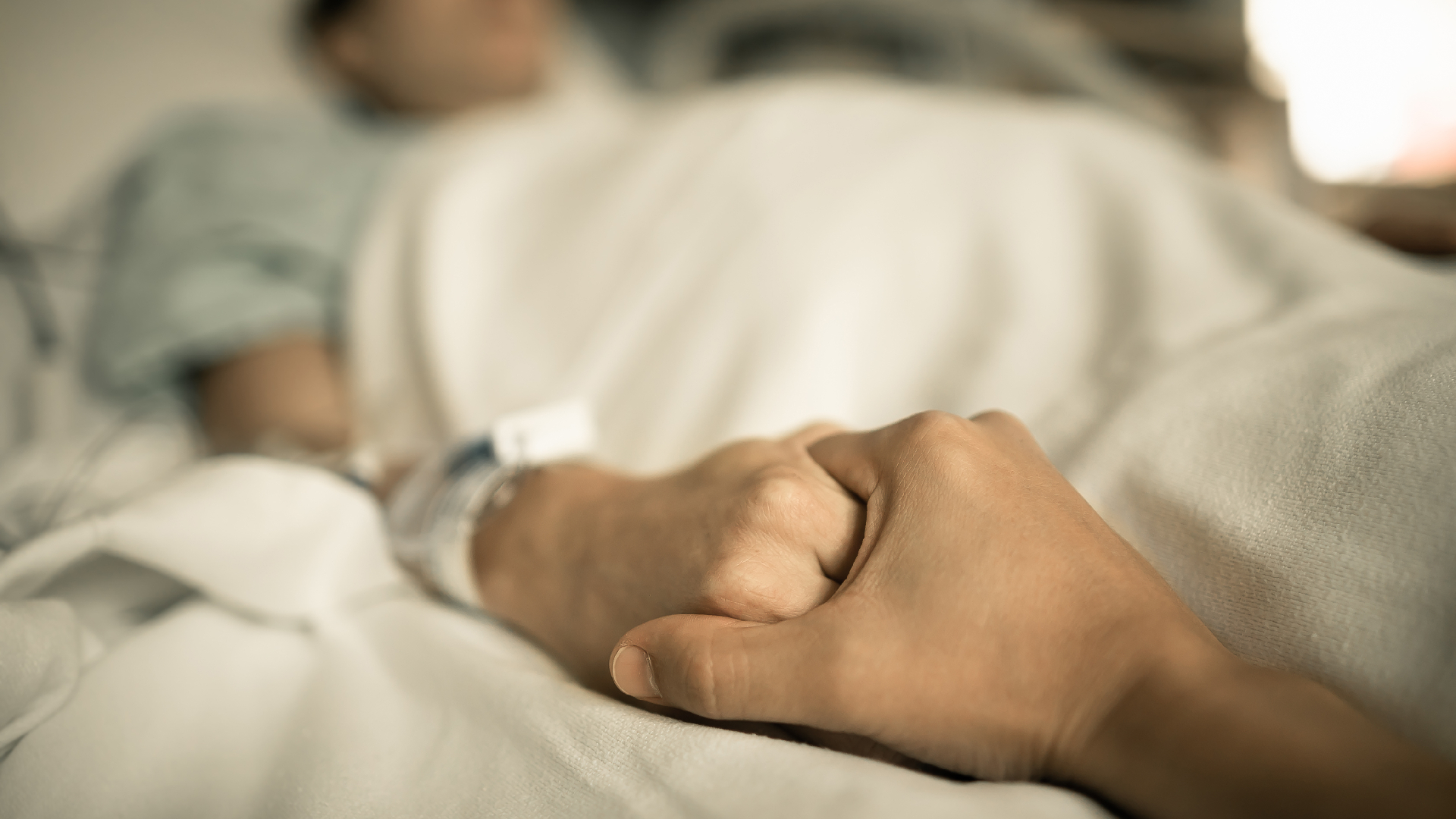 Two people holding hands in a hospital.