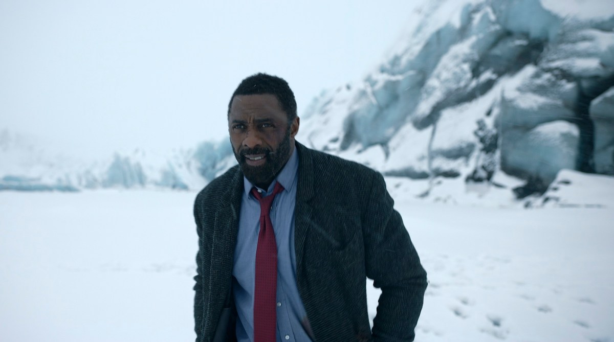 Idris Elba in Luther walks through the snow.