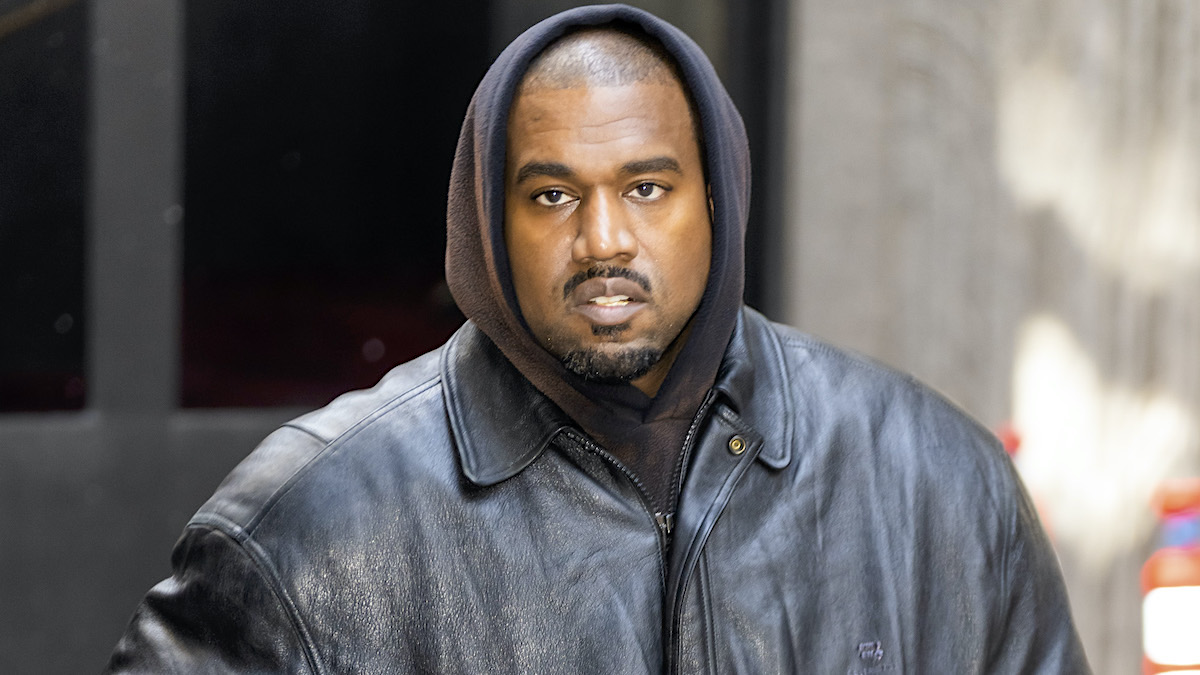 Kanye West in a black leather jacket and brown hoodie