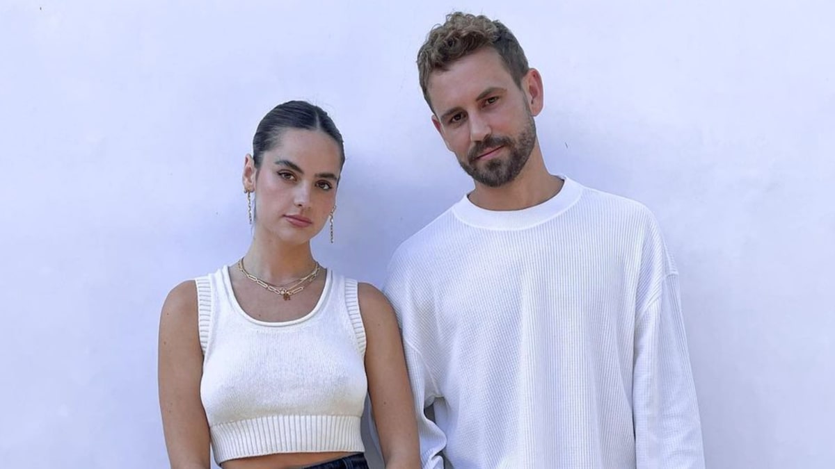 Nick Viall and Natalie Joy pose against a whitewall
