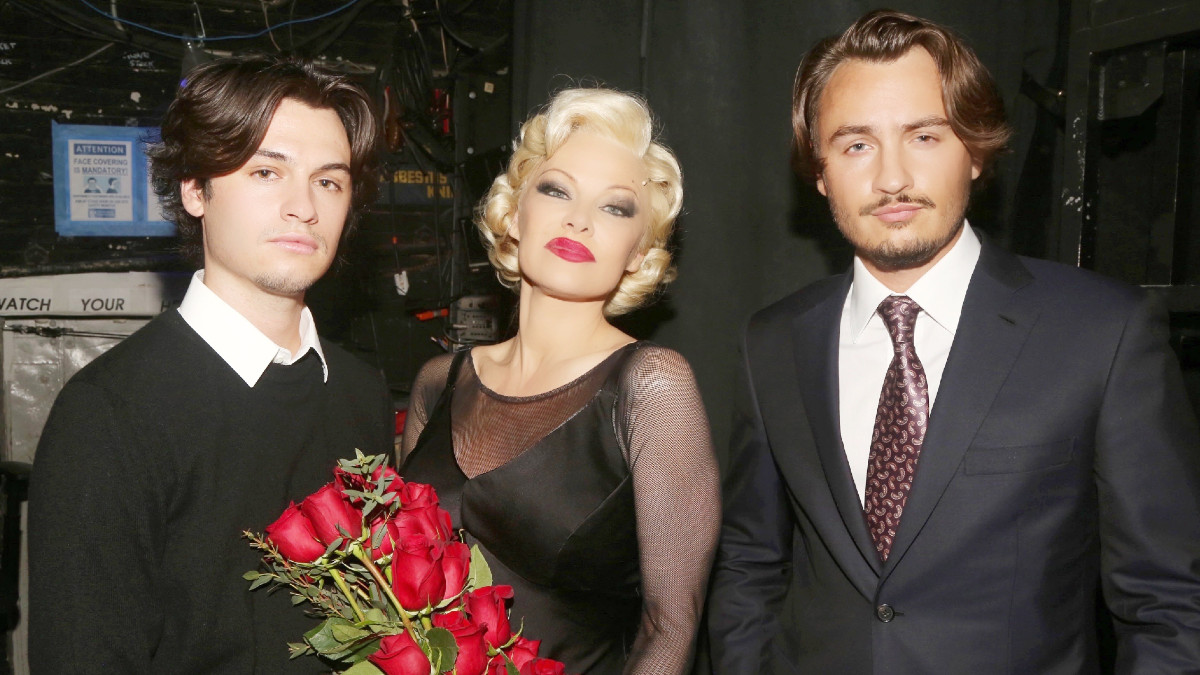 Dylan Jagger Lee, Pamela Anderson and Brandon Thomas Lee pose backstage during the opening night of her Broadway debut as Roxie Hart in the musical "Chicago" on Broadway at the Ambassador Theatre on April 12, 2022 in New York City.